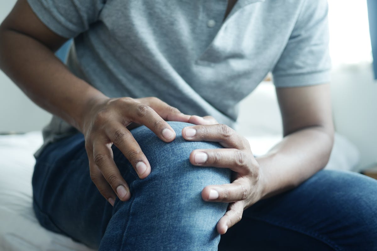 Person holding knee experiencing morning joint stiffness